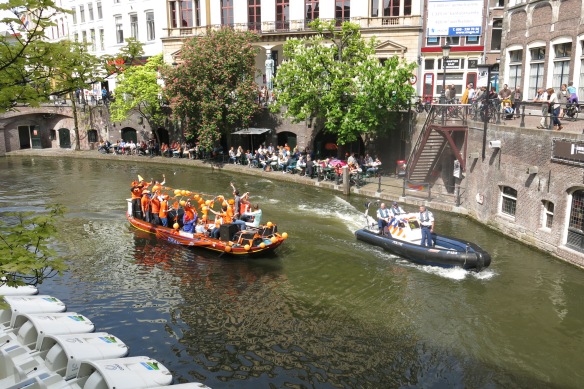 Happy party boat on the Oudergracht (Old Canal). Note the police patrol boat to the right and how amused they are!