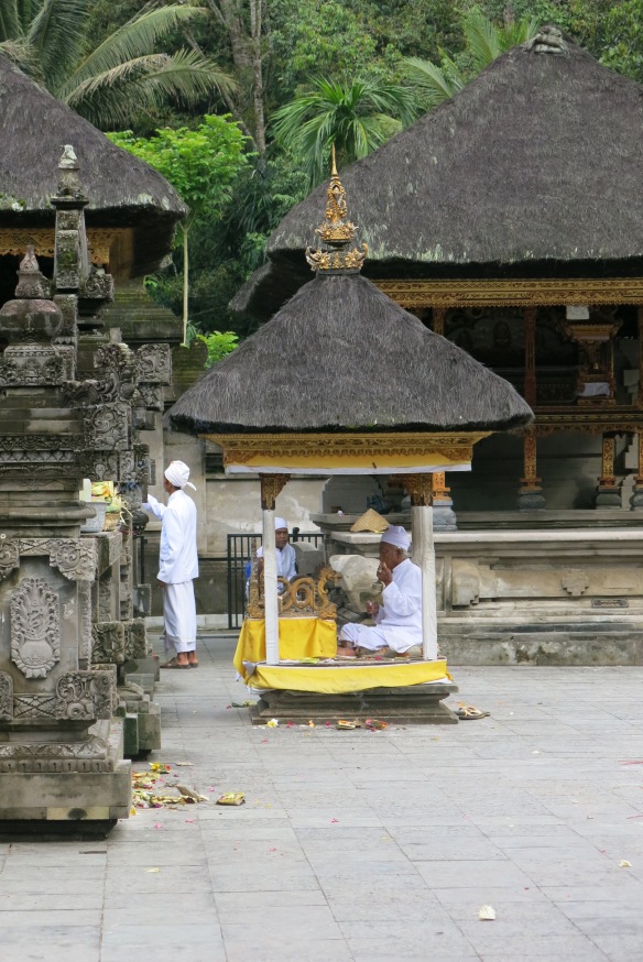Tirta priests, dressed completely in white, lead ceremonies within the sanctum of the Pura Tirta Empul.